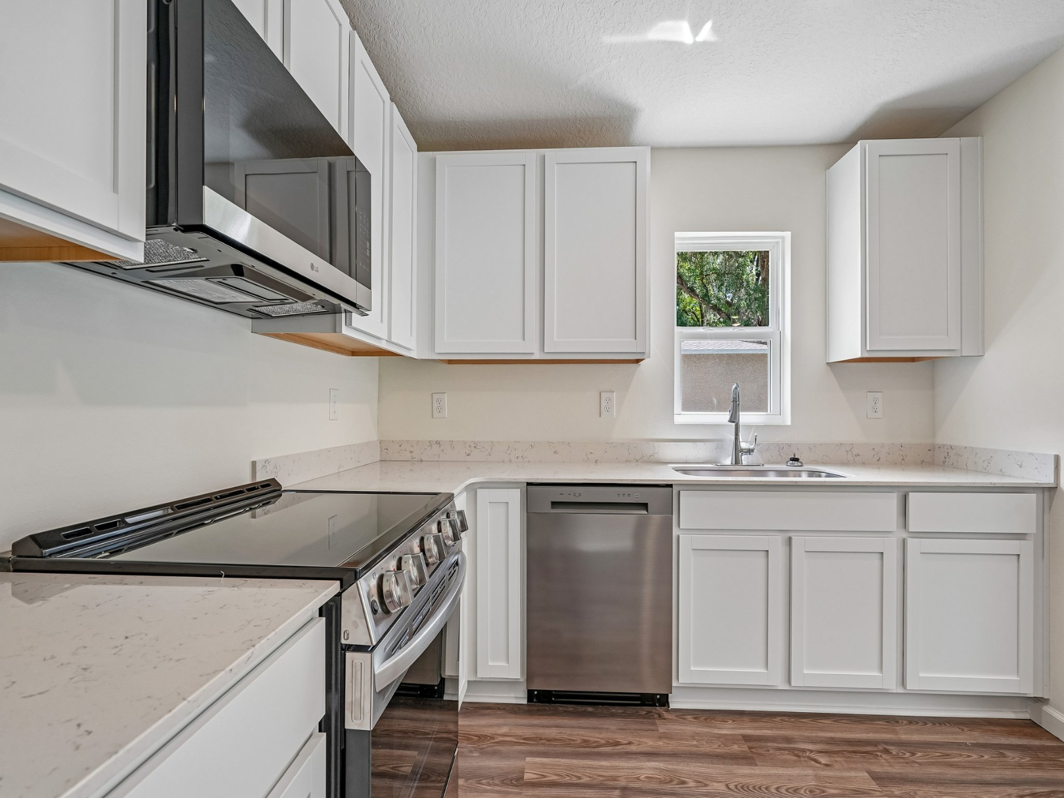 A kitchen with white cabinets.