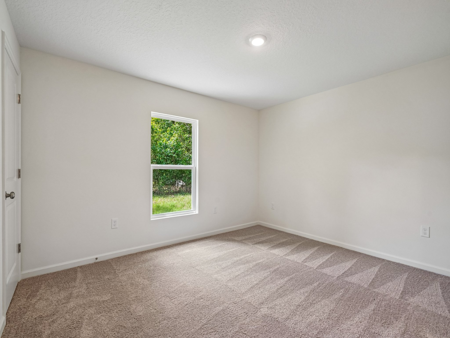 A room with a window and carpet.