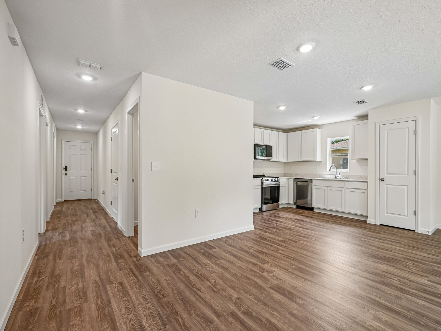 A large empty room with white cabinets.