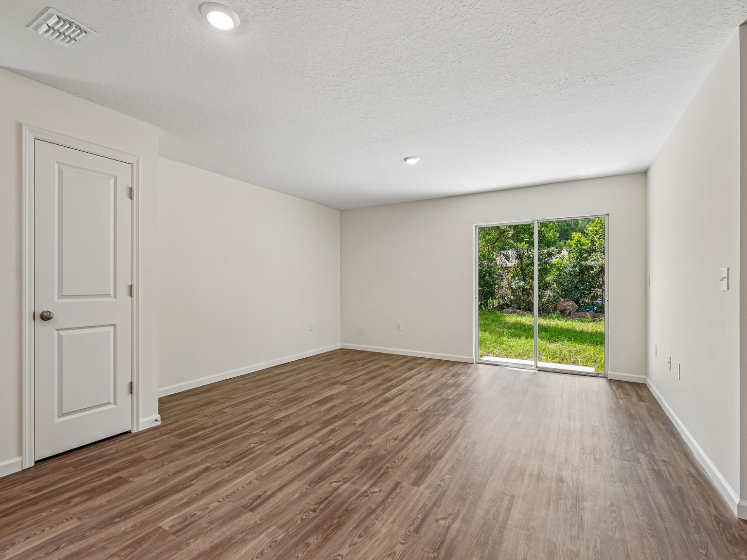A room with a wood floor and a wood floor with a window.