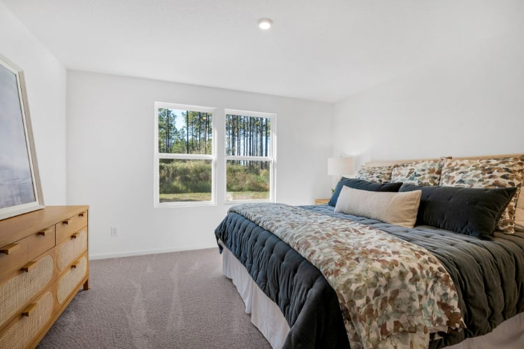 A bedroom with a bed and a window.