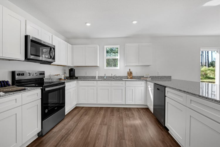 A kitchen with white cabinets.