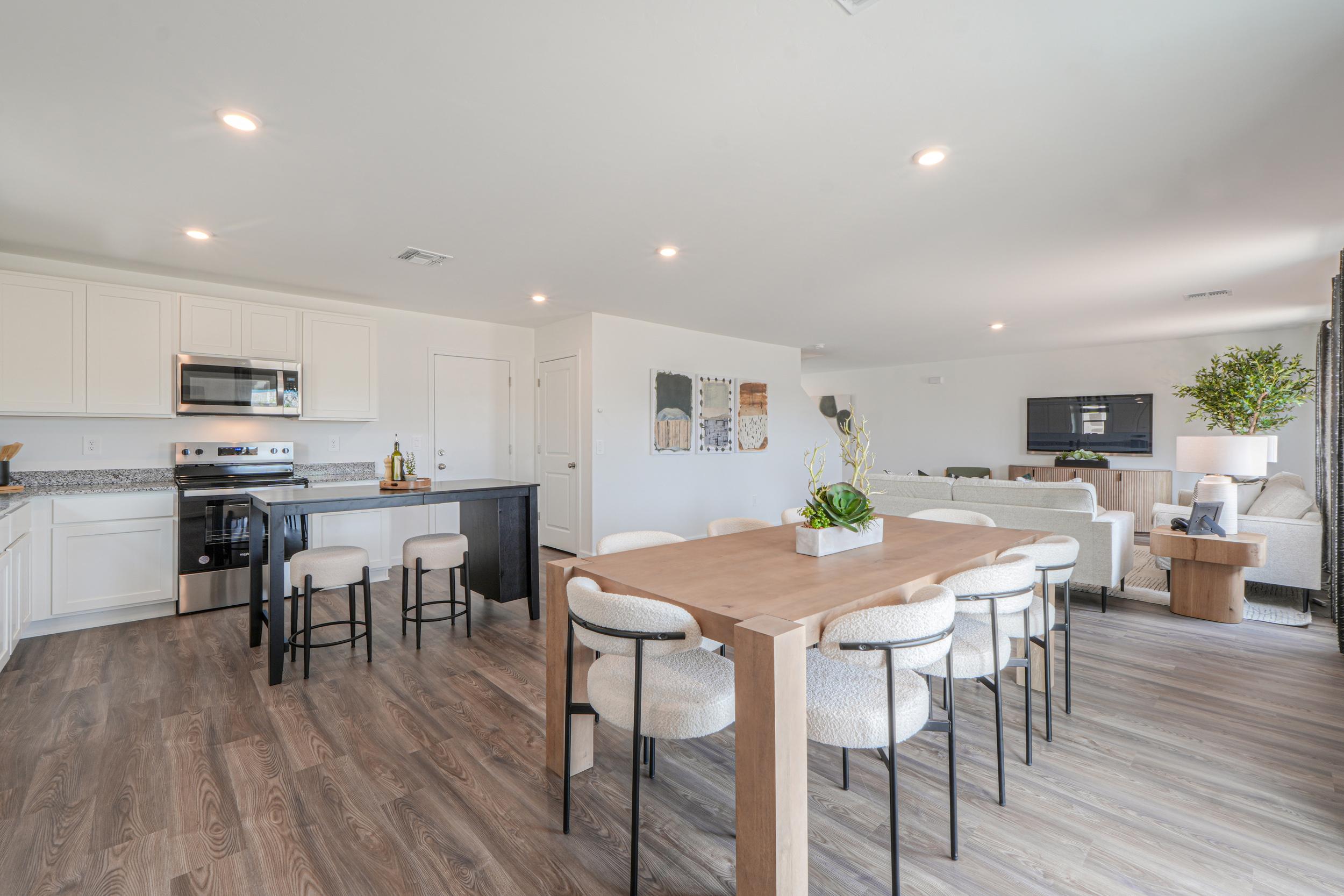 A kitchen with a table and chairs.