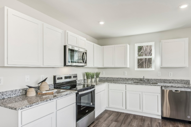A kitchen with white cabinets.