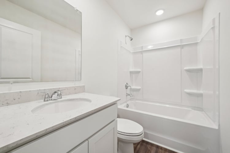 A bathroom with a tub sink and toilet.