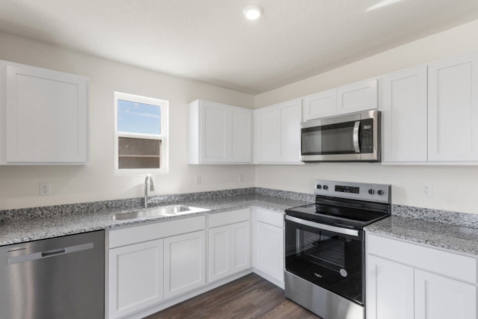 A kitchen with white cabinets.