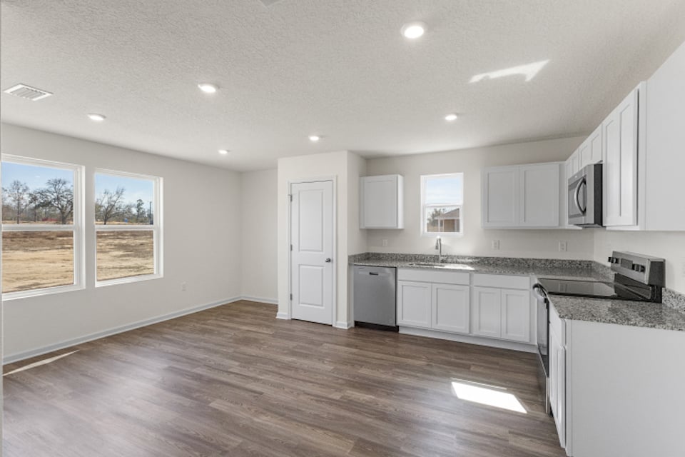 A kitchen with white cabinets.