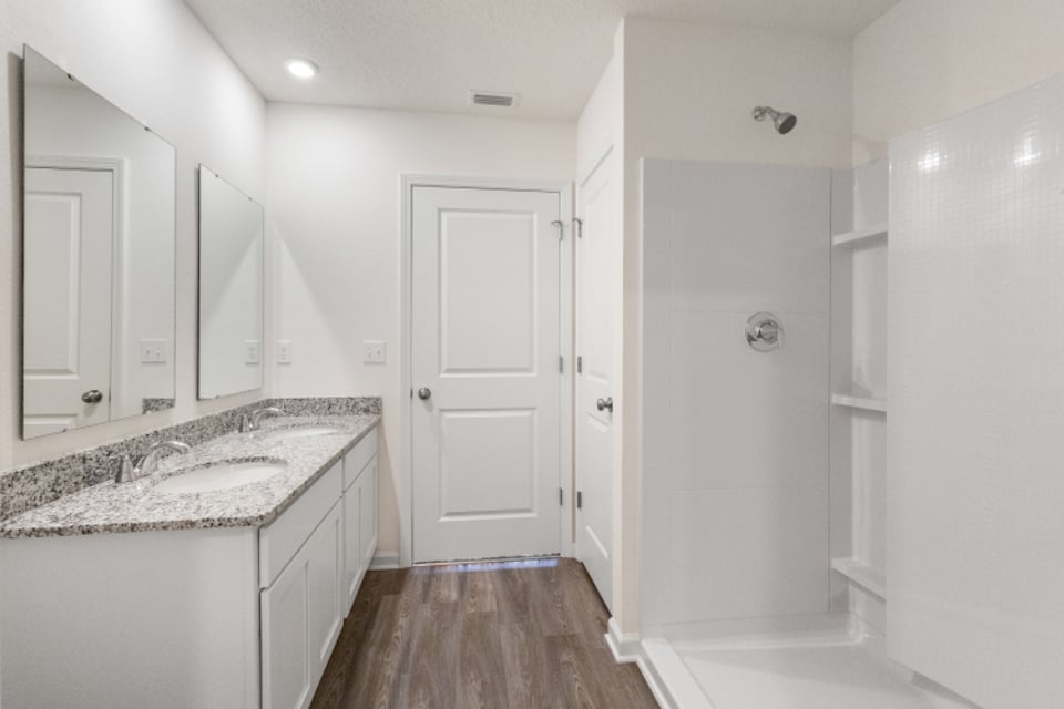 A bathroom with white cabinets.