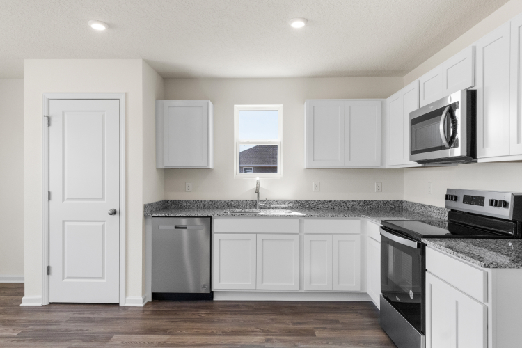 A kitchen with white cabinets.