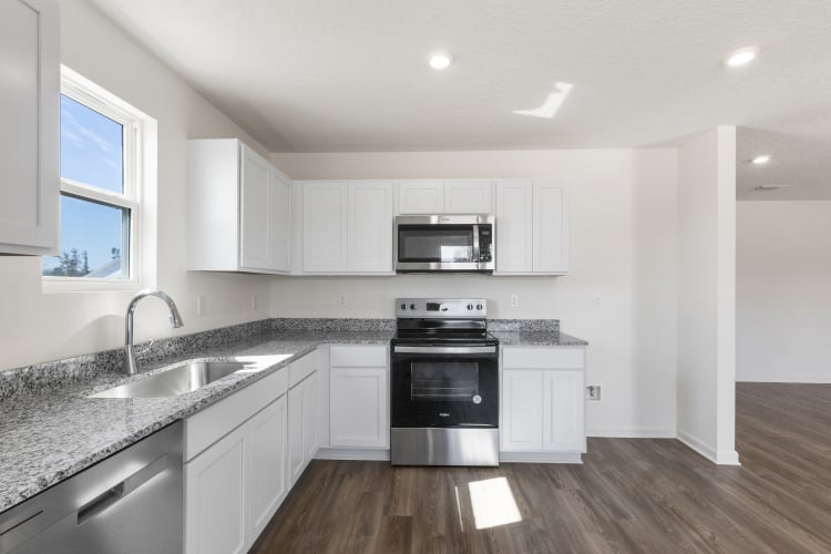 A kitchen with white cabinets.