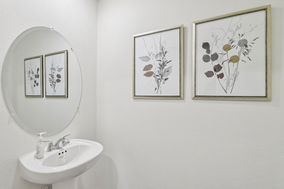 A bathroom with a couple of pictures on the wall.