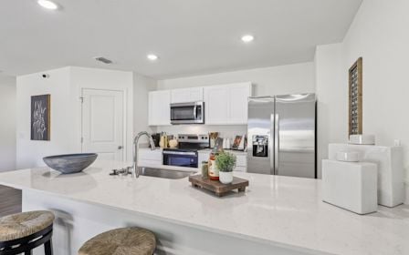 A kitchen with white cabinets.