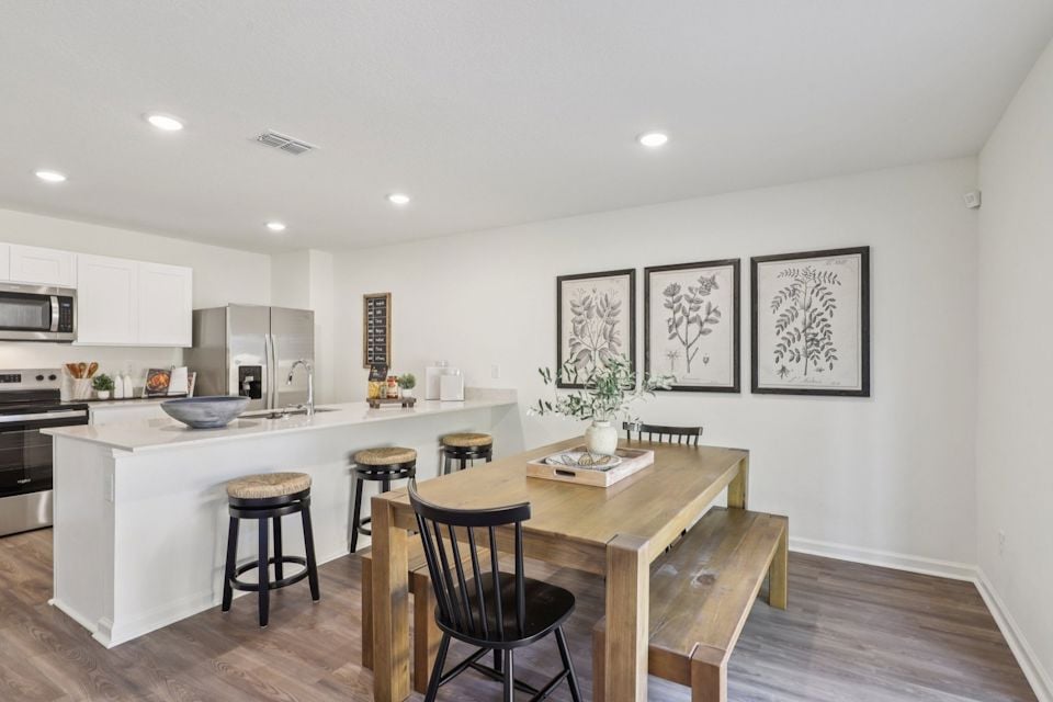 A kitchen with a table and chairs.