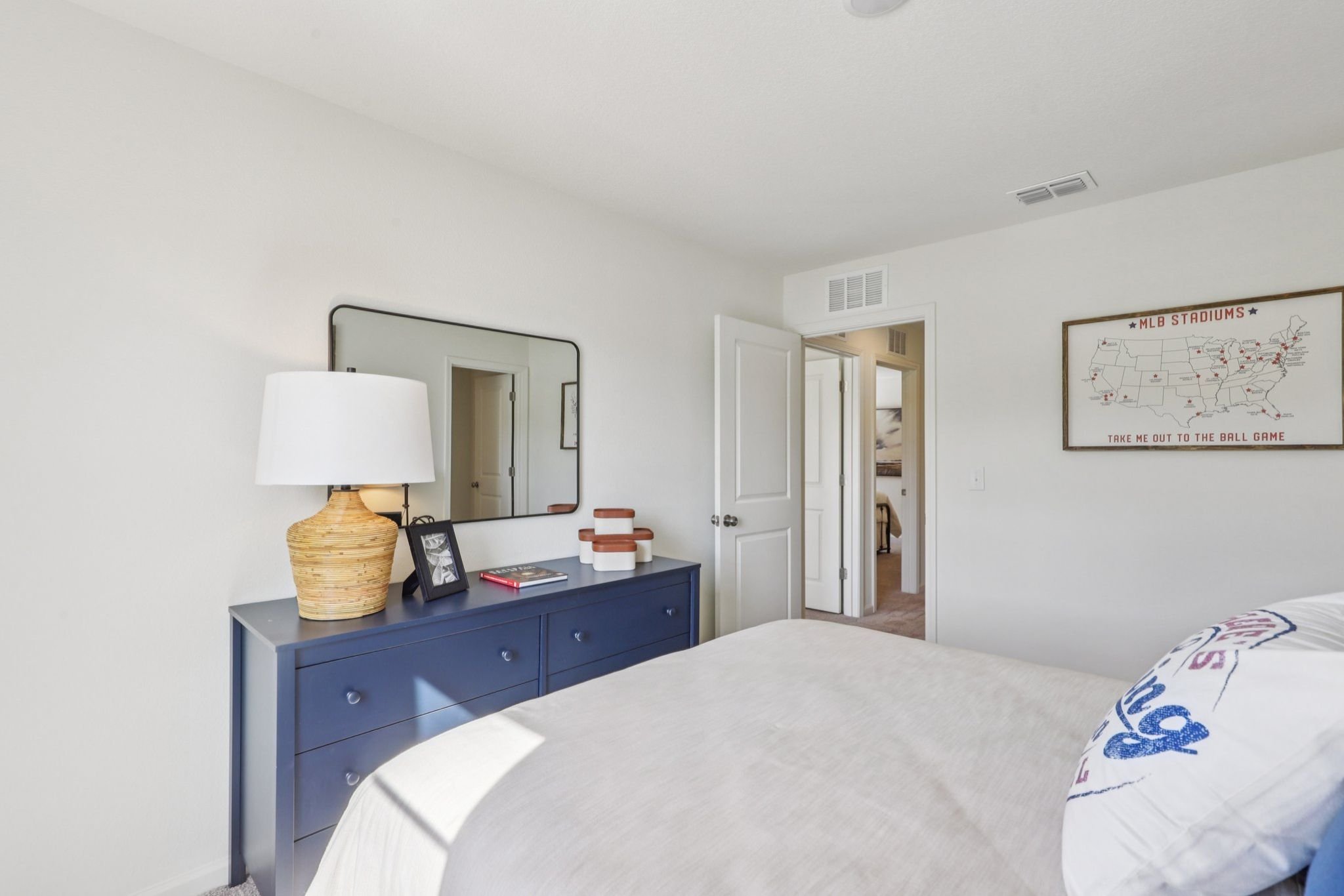 A bedroom with a bed and a mirror.