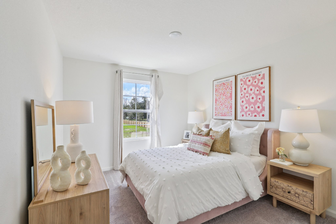 A bedroom with a bed and lamps.
