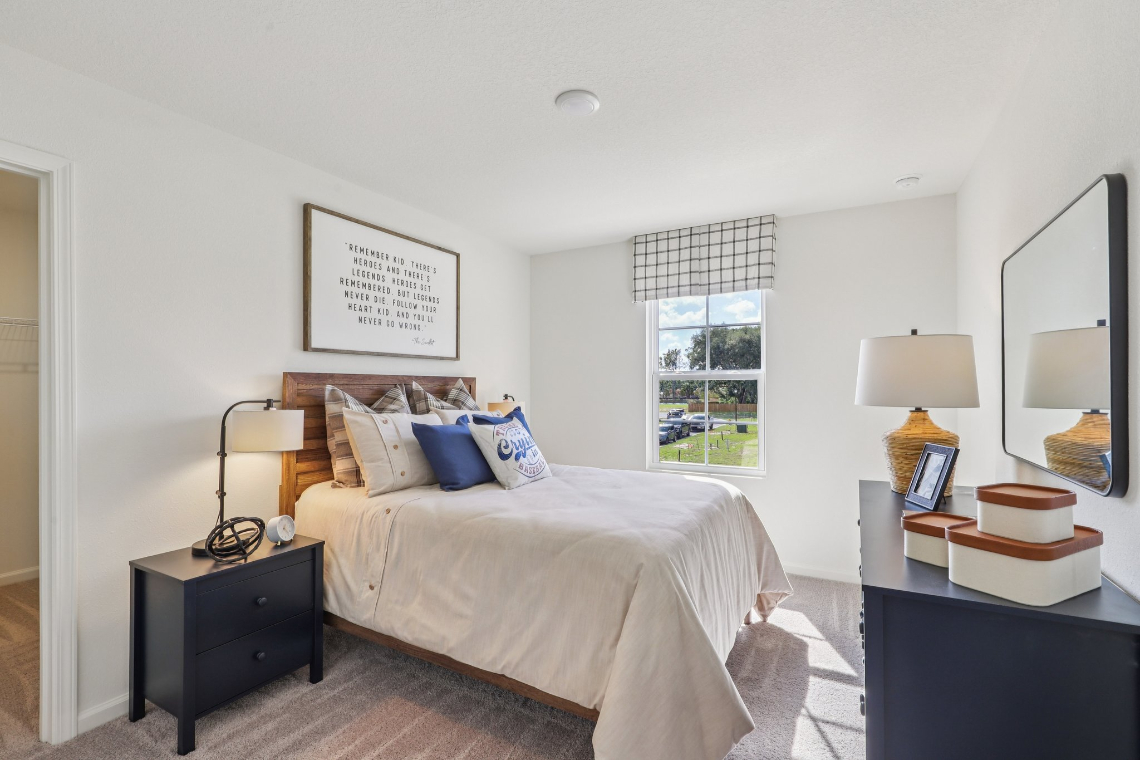 A bedroom with a bed and lamps.