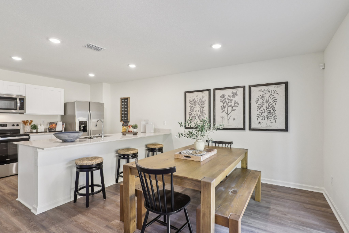 A kitchen with a table and chairs.