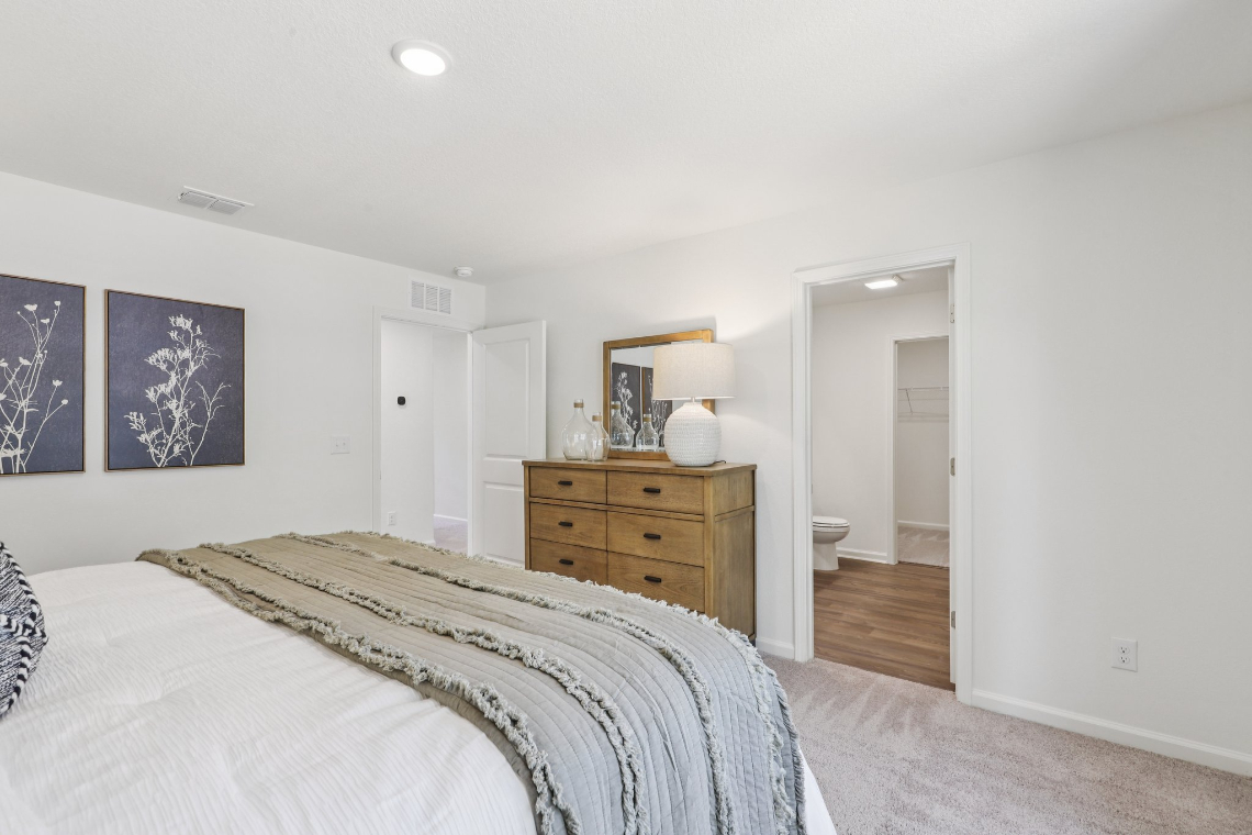 A bedroom with a bed and a dresser.