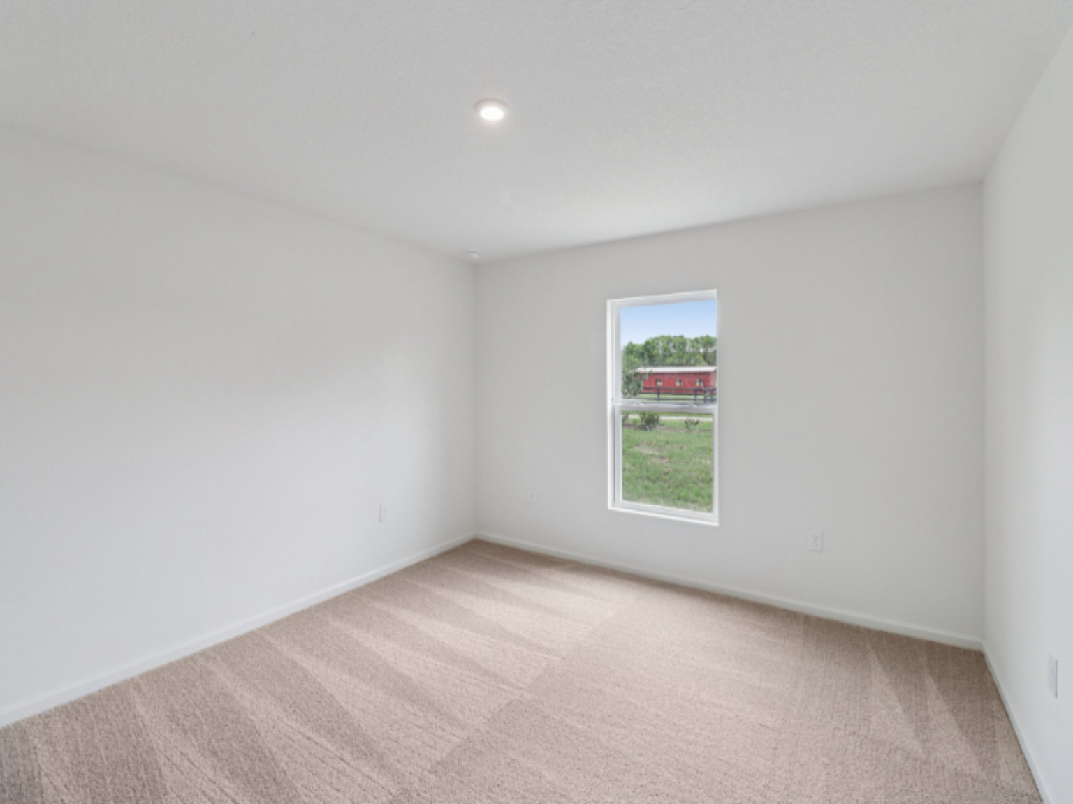 A room with a window and a wood floor.