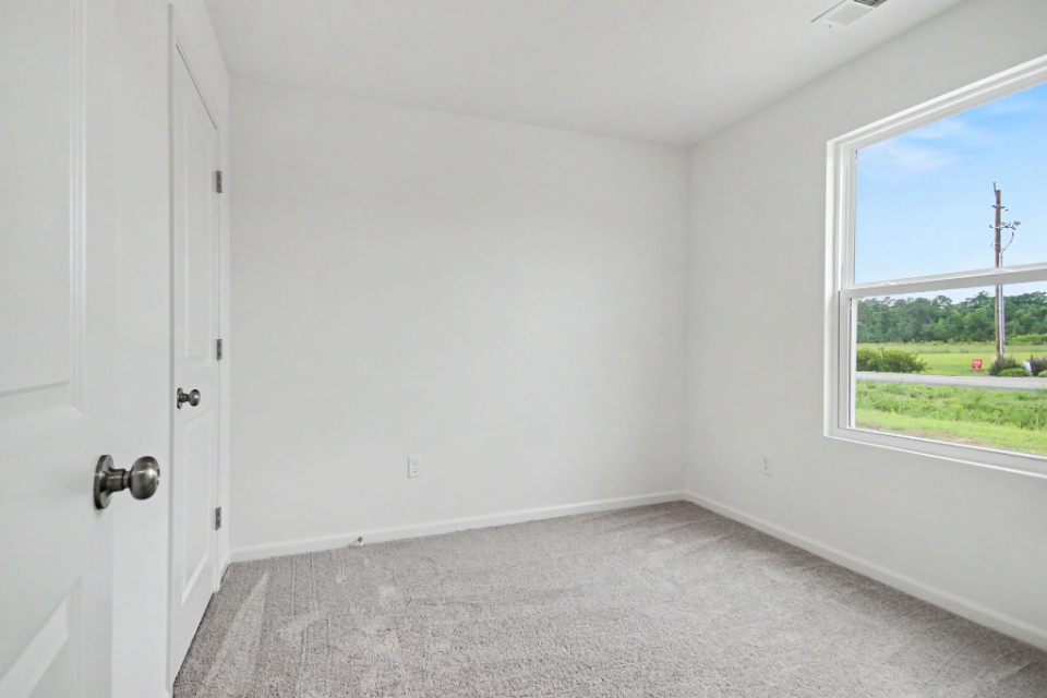 A room with a window and a carpet.