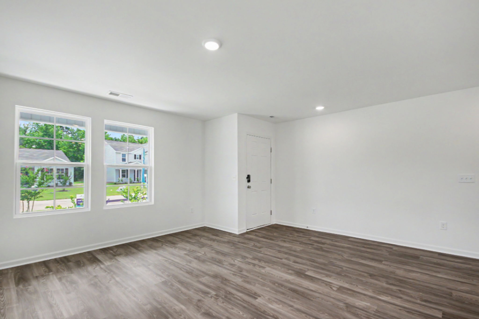 A room with a wood floor and a wood floor with a white door.