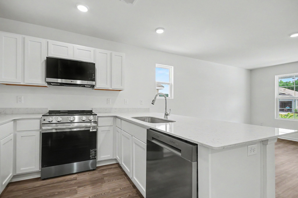 A kitchen with white cabinets.