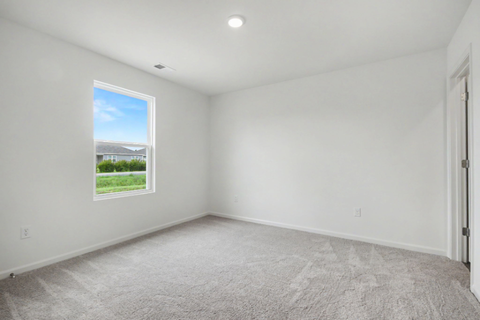 A room with a window and a carpet.