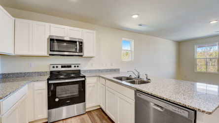 A kitchen with white cabinets.