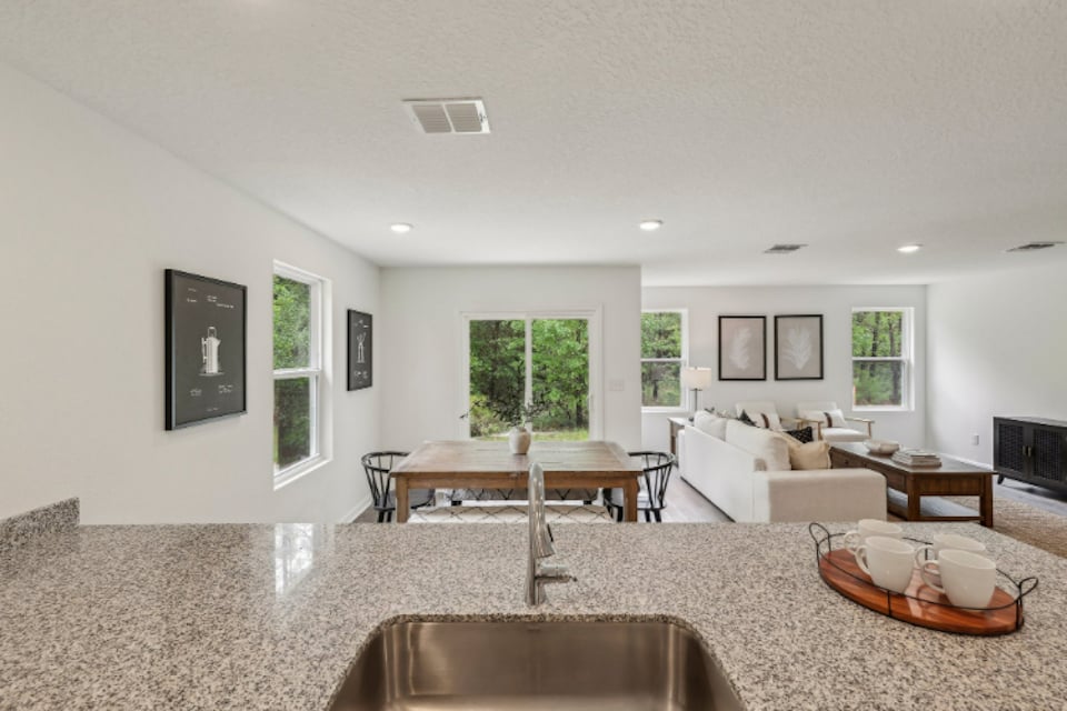A living room with a large table and chairs.