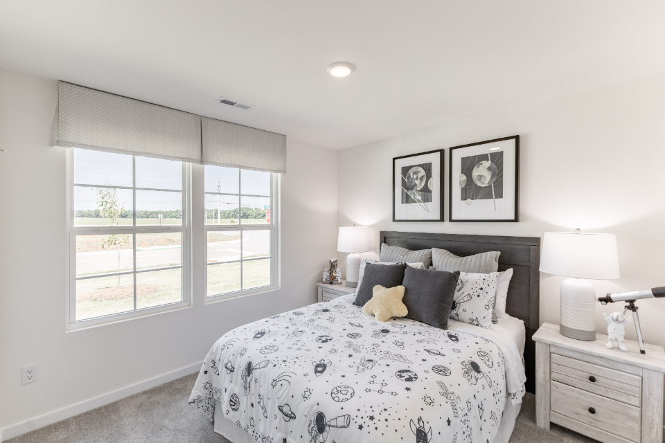 A bedroom with a bed and a window.