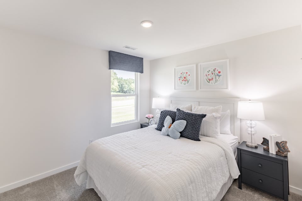 A bedroom with a bed and lamps.