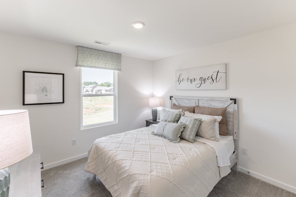 A bedroom with a bed and a window.
