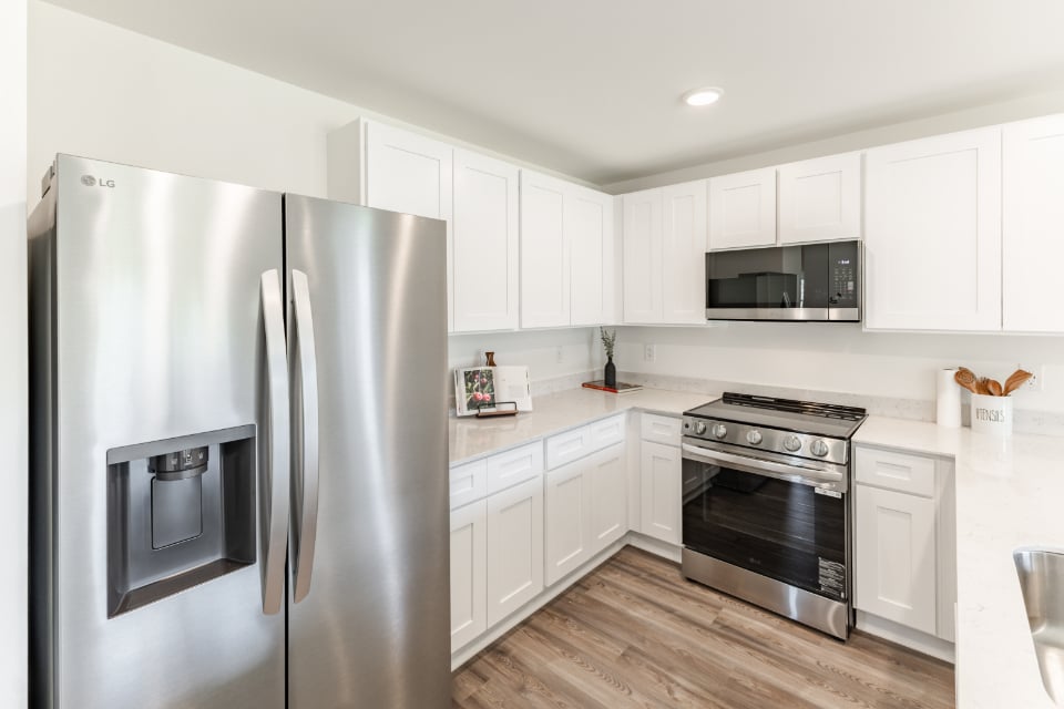 A kitchen with white cabinets.