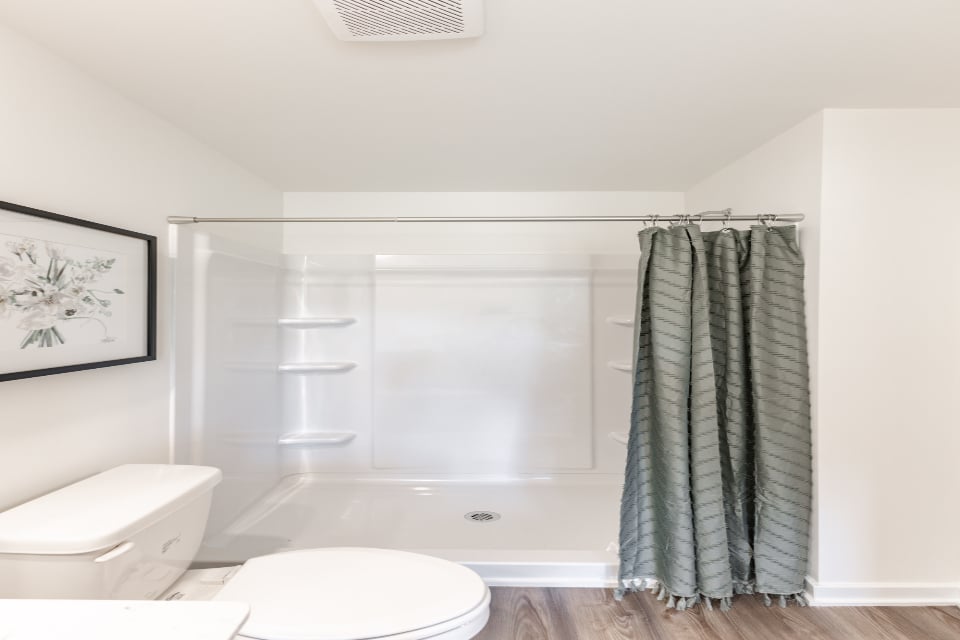 A bathroom with a shower and toilet.