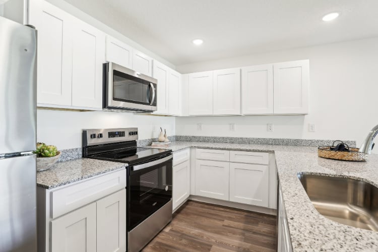 A kitchen with white cabinets.