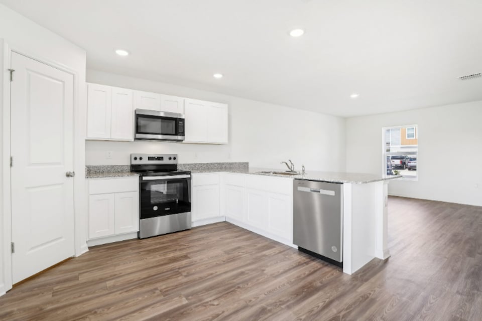 A kitchen with white cabinets.