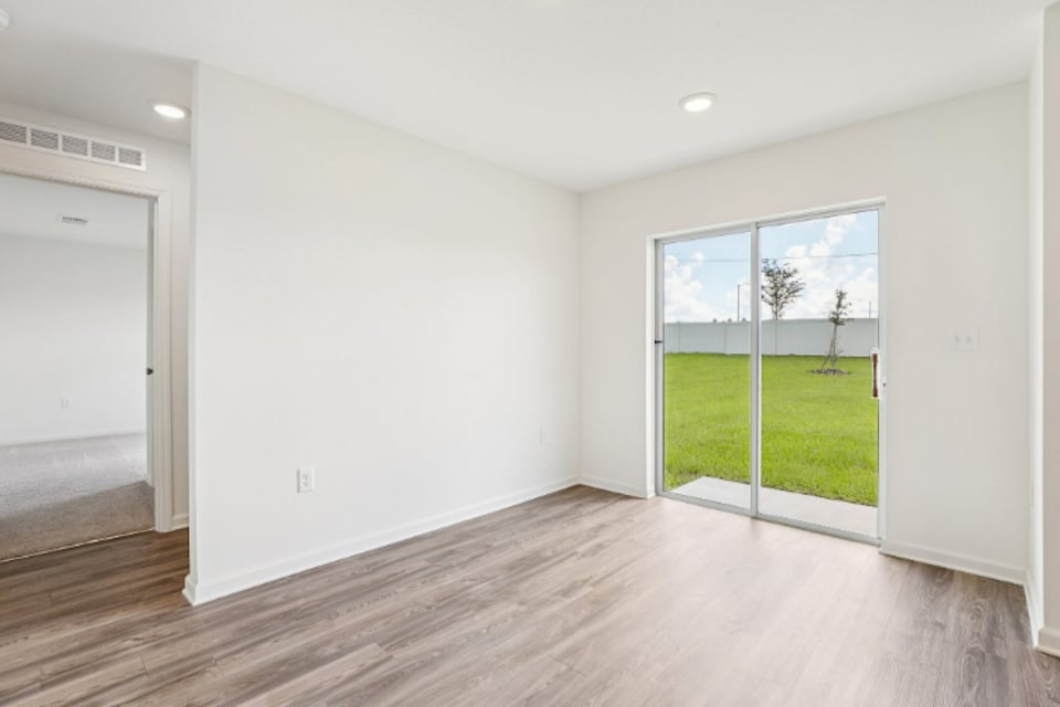 A room with a wood floor and a large window.