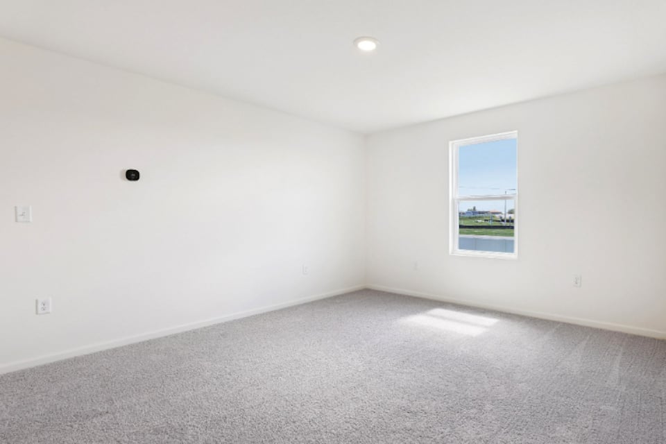 A room with a window and a carpet.