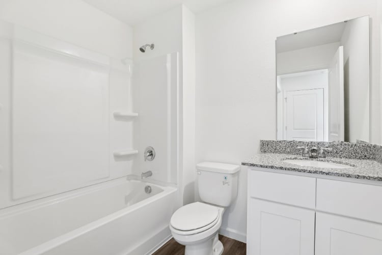 A bathroom with a tub toilet and sink.