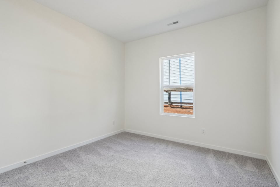 A room with a window and a carpet.