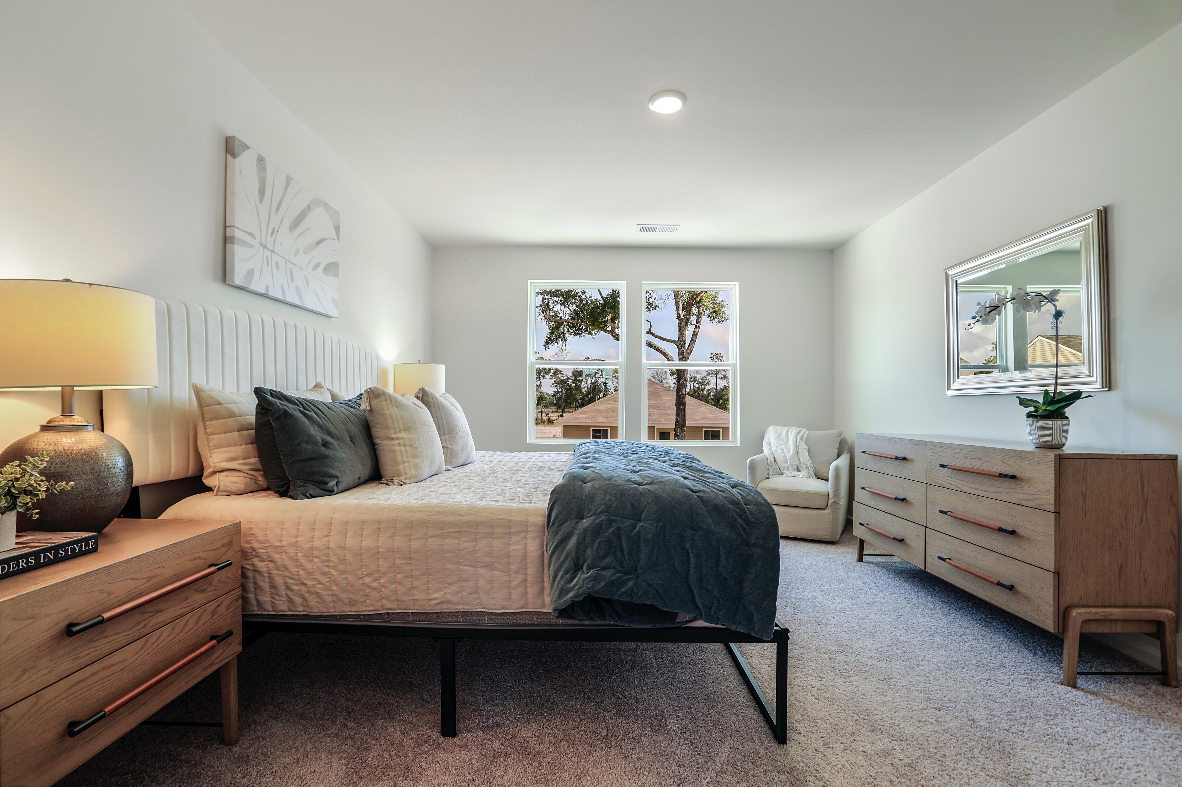 A bedroom with a bed and a bench.