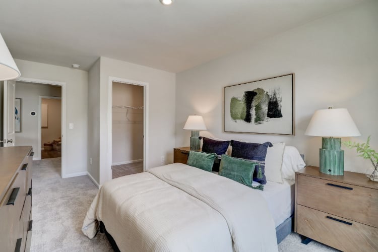 A bedroom with a bed and lamps.