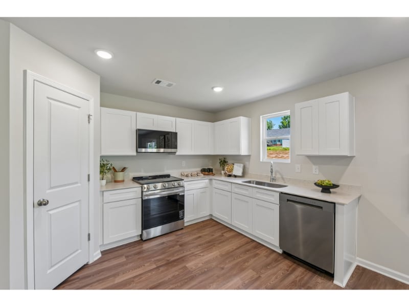 A kitchen with white cabinets.