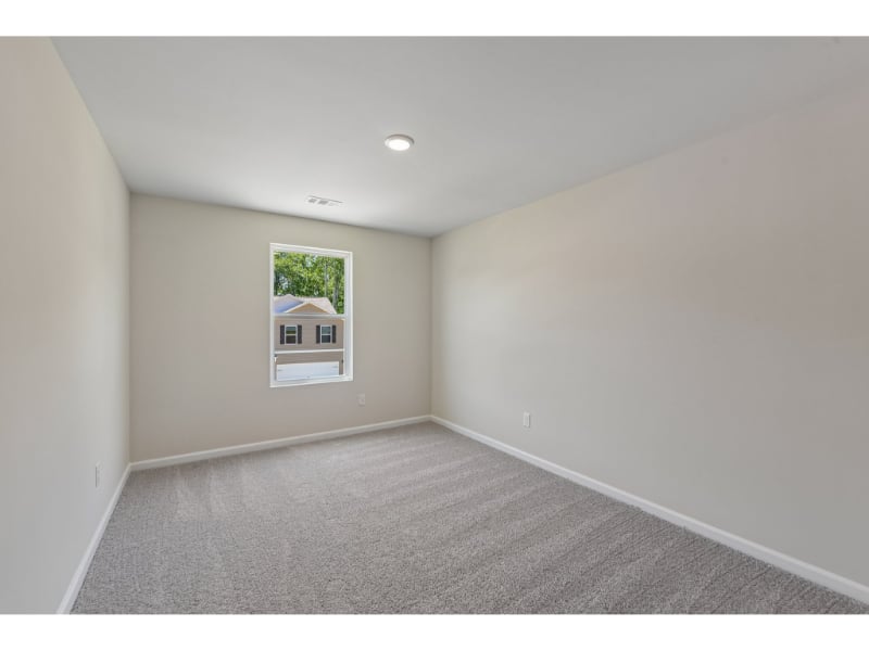 A room with a window and a carpet.
