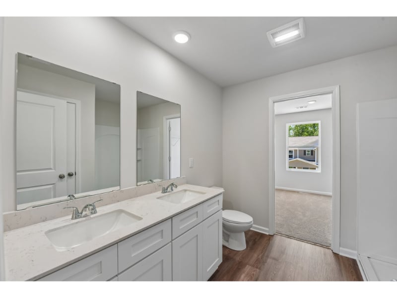 A bathroom with white cabinets.