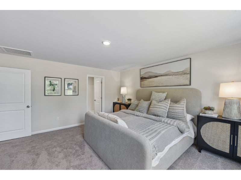 A bedroom with a bed and lamps.