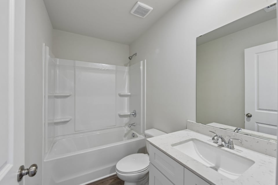 A bathroom with a tub sink and toilet.