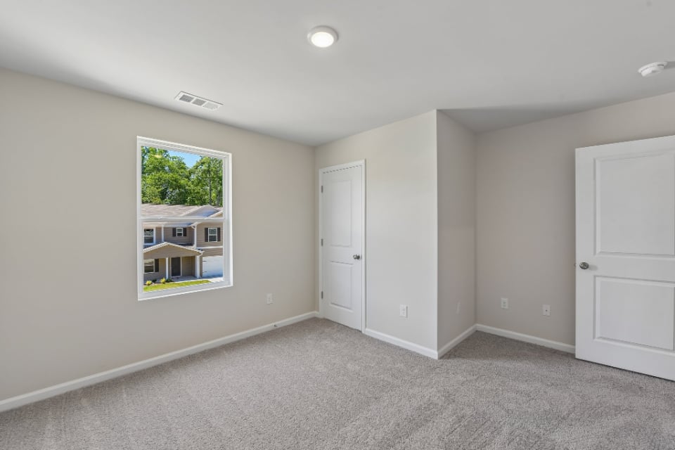 A room with white walls and a window.