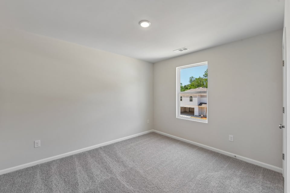 A room with a window and a carpet.