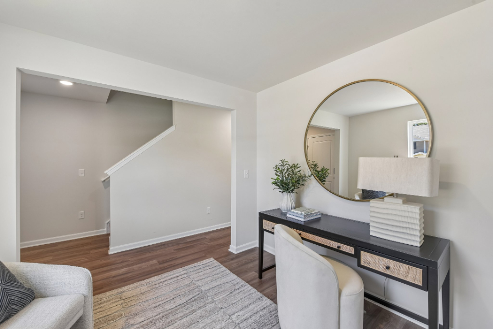 A room with a mirror and a desk.